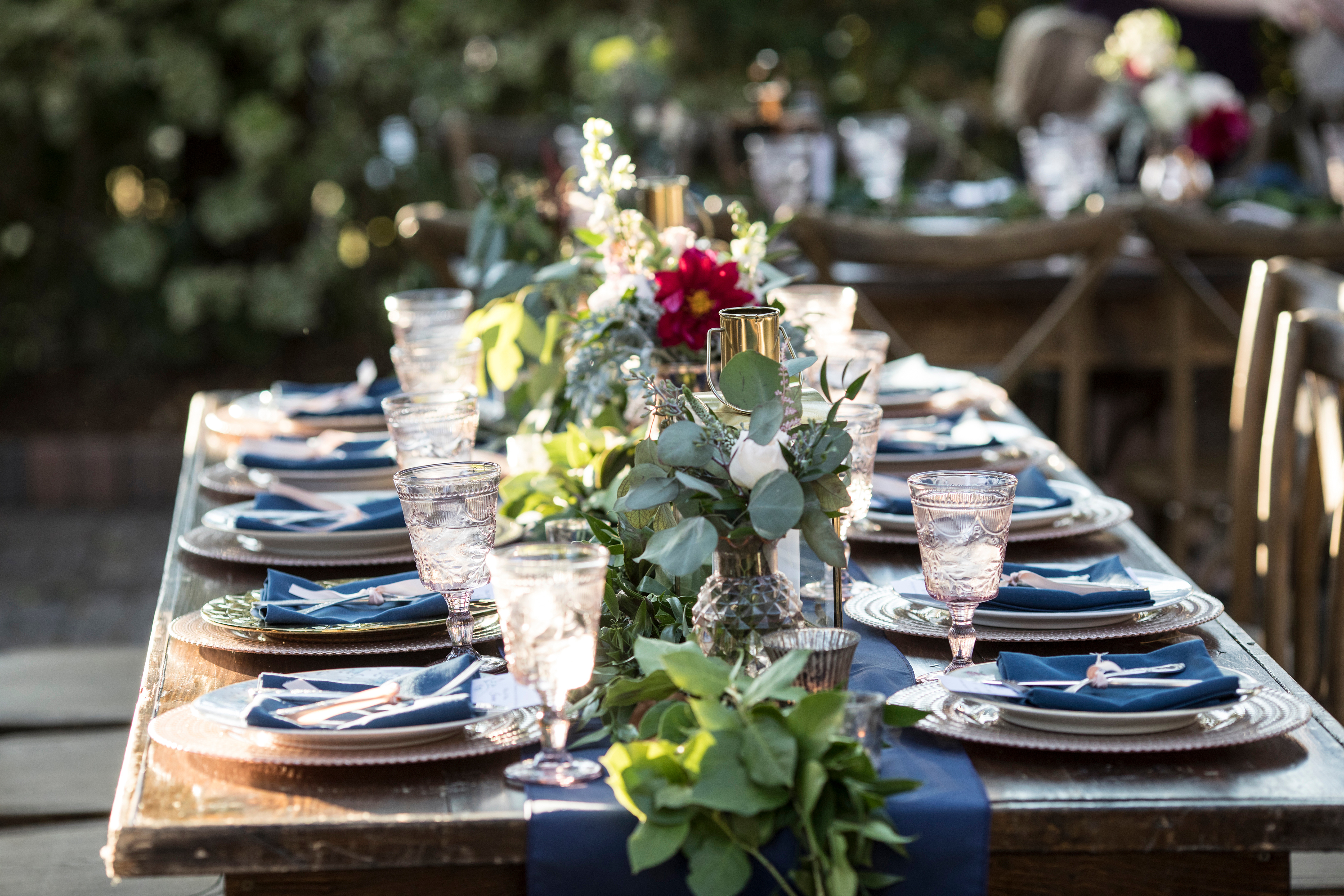Outdoor table set up for wedding reception with flowers and antique fixtures